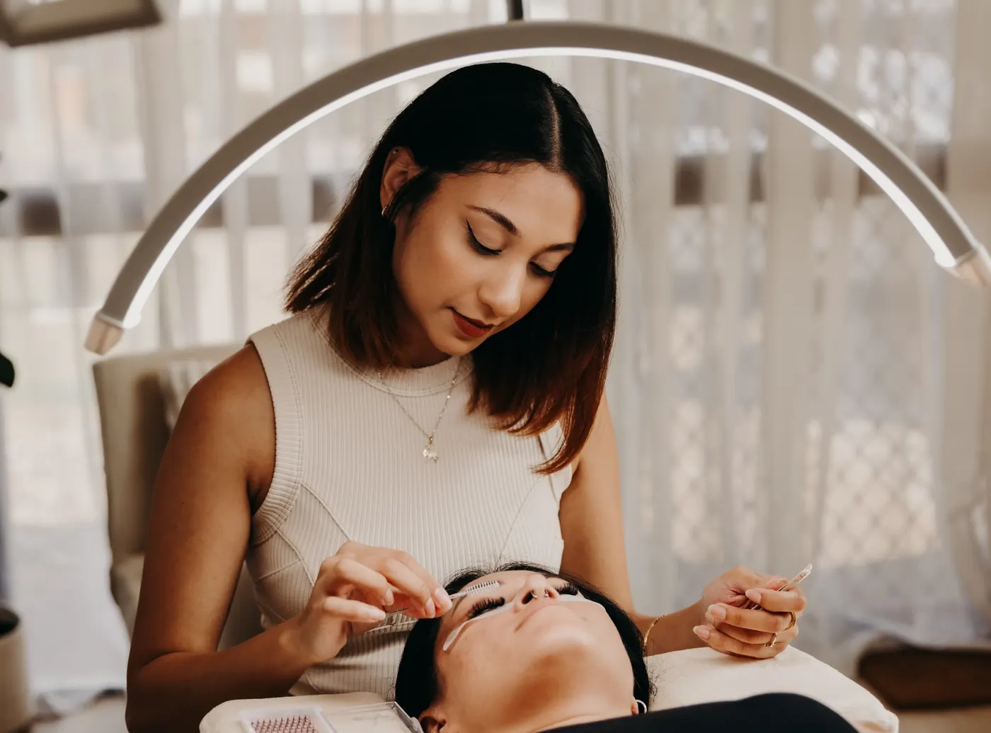 Sheryline applying lash extensions to a client at The Little Lounge in Bundaberg